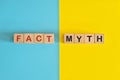 Fact versus myth information concept. Wooden blocks typography in bright blue and yellow background. Royalty Free Stock Photo