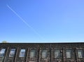 Factories windows blue sky and a plane Royalty Free Stock Photo
