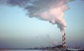 Factory brick chimney. The smoke from the pipe cogeneration plant. Steam escaping from a trumpet on the sky background Royalty Free Stock Photo