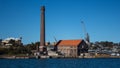 Factory brick smoke stack at historic dockyard and boat storage with crane against blue sky set on Cockatoo Island Sydney Harbour Royalty Free Stock Photo