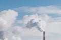 Factory chimney blowing smoke in blue sky background Royalty Free Stock Photo