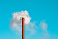 Factory chimney blowing smoke from pipe in blue sky Royalty Free Stock Photo