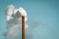 Factory chimney blowing white smoke from pipe in blue sky Royalty Free Stock Photo