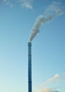 A factory chimney with smoke billowing into the air. Large amounts of steam or smoke billowing from an industrial smoke