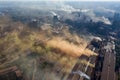 Factory chimneys emit a caustic chemical fume that disrupts the city's ecology