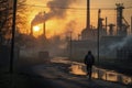 Factory chimneys stand tall, belching plumes of smoke into the sunset-painted sky. Royalty Free Stock Photo