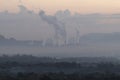 A factory emits smoke from its stacks, and Air pollution over the coal power plant Mae Moh Lampang in the morning with fog, Royalty Free Stock Photo