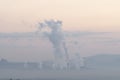 A factory emits smoke from its stacks, and Air pollution over the coal power plant Mae Moh Lampang in the morning with fog, Royalty Free Stock Photo