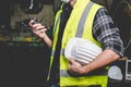 A factory worker holds a hard hat and talks a radio Royalty Free Stock Photo