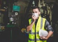 A factory worker holds a hard hat and talks a radio Royalty Free Stock Photo