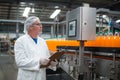 Factory engineer maintaining record on clipboard in factory