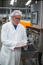 Factory engineer maintaining record on clipboard in factory Royalty Free Stock Photo