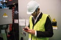 Factory engineer using smartphone at machine