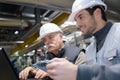 Factory engineers looking at laptop