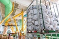 Factory and industrial concept. Stacked sacks against technological equipment pipes at modern pharmaceutical factory plant