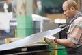 Factory man worker holding metal sheet in workshop