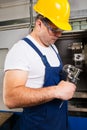 Factory man worker measuring steel detail with digital Vernier Caliper at workshop