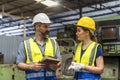 Factory manager and worker. Young man and Young woman are discussing in industrial plants. Engineer with clipboard and tablet on Royalty Free Stock Photo