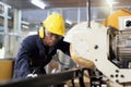 A factory mechanic is using a chainsaw to cut copper pipes. An expert technician is inspecting industrial machinery in a steel Royalty Free Stock Photo