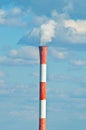 Factory pipe smoking against blue sky