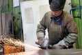 Factory welder worker grinding steel sheet at workshop