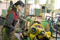 Factory woman turner working on workshop lathe machine