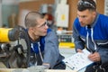 Factory worker and apprentice marking workpiece Royalty Free Stock Photo