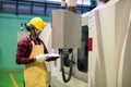 Factory worker check manual paper to command CNC panel Royalty Free Stock Photo