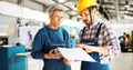 Factory worker discussing data with supervisor in metal factory Royalty Free Stock Photo