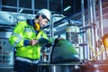 Factory worker engineer working in factory using tablet computer to check maintenance boiler water pipe in factory