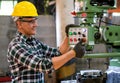 Factory worker man stand and press button of the machine to work in workplace also look happy by smiling. Concept of good Royalty Free Stock Photo