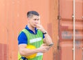 Factory worker man uses mobile phone, engineer using mobile smartphone in industry containers cargo