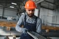 Factory worker measures the metal profile