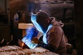 Factory worker in protective mask welding iron parts Royalty Free Stock Photo