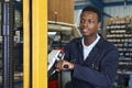 Factory Worker Using Powered Fork Lift To Load Goods