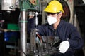 Factory worker wearing face mask for protect virus, using the machine in factory Royalty Free Stock Photo