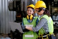 Factory worker women discuss together with laptop in workplace area. Concept of good teamwork and management system help and Royalty Free Stock Photo