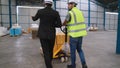 Factory workers deliver boxes package on a pushing trolley in the warehouse . Royalty Free Stock Photo