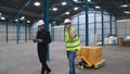 Factory workers deliver boxes package on a pushing trolley in the warehouse . Royalty Free Stock Photo