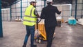 Factory workers deliver boxes package on a pushing trolley in the warehouse . Royalty Free Stock Photo