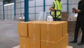 Factory workers deliver boxes package on a pushing trolley in the warehouse . Royalty Free Stock Photo