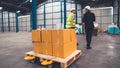 Factory workers deliver boxes package on a pushing trolley in the warehouse . Royalty Free Stock Photo