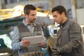 Factory workers discussing with digital tablet in warehouse