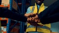 Factory workers stacking hands together in warehouse or storehouse Royalty Free Stock Photo