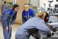 Factory workers wearing ear defenders examining machinery