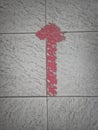 Faded arrow-shaped red duct tape on the floor Royalty Free Stock Photo