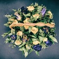 Faded bouquet of flowers on a black background. Top view of dried blue and yellow roses. Dry autumn flowers in a wicker basket Royalty Free Stock Photo