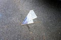 A faded American flag lies forgotten on the pavement of a street