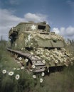 Faded green fields with a brokendown halftrack are speckled with s of daisies. Abandoned landscape. AI generation Royalty Free Stock Photo