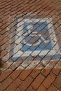 Faded handicapped parking sign on cobblestone bricks Royalty Free Stock Photo